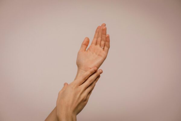 Close-up of hands gently caressing each other, symbolizing self-care and softness.